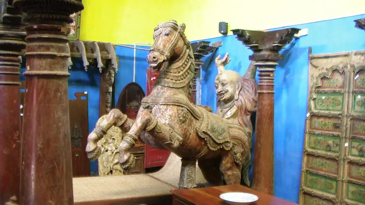 Handcrafted wooden horse and other handicrafts from a Kerala antiques shop.