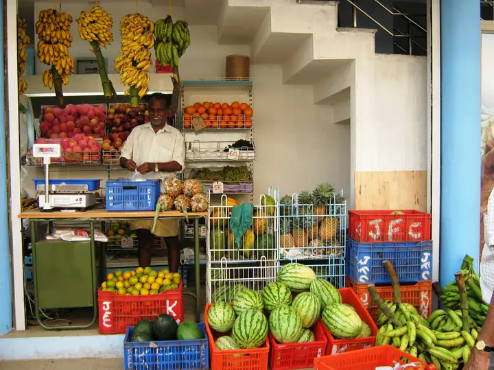 A street vegetable vendor in Kannur, Kerala, surrounded by fresh produce.